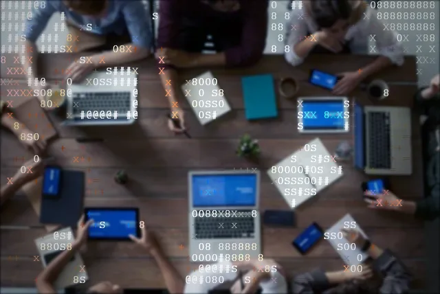 Top-down view of a team planning around a desk with devices