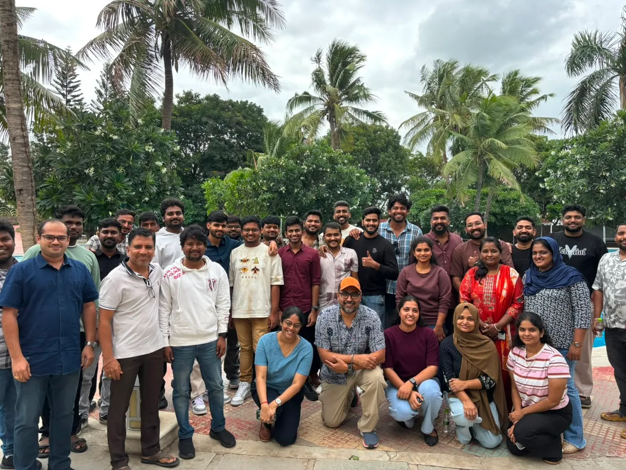 The team gathered for a group photo by the poolside at a resort offsite